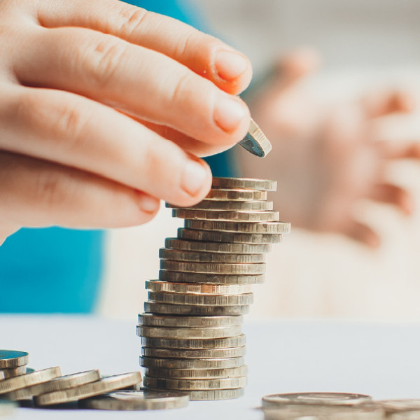 A kid adds a nickel to a stack of coins.