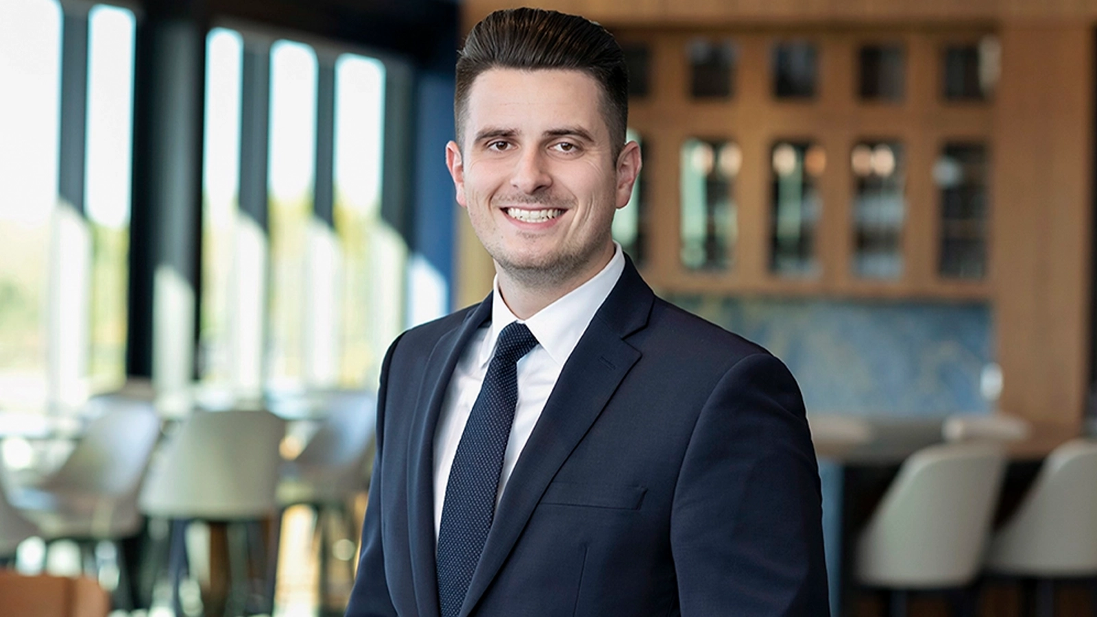 Man in black suit smiling