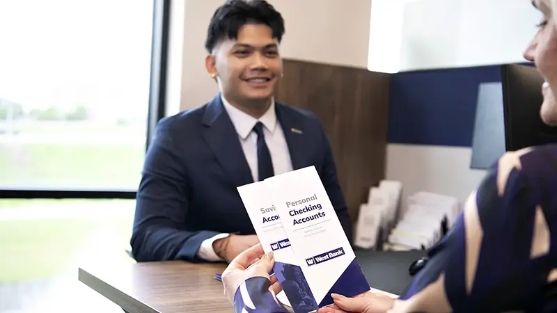 banker handing brochure to customer