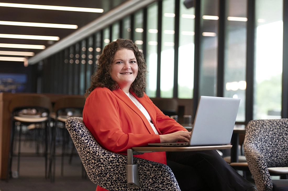 woman in orange blazer with laptop