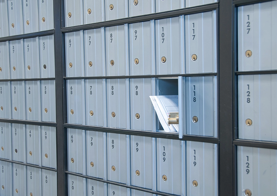 A bunch of post office mailboxes with one open