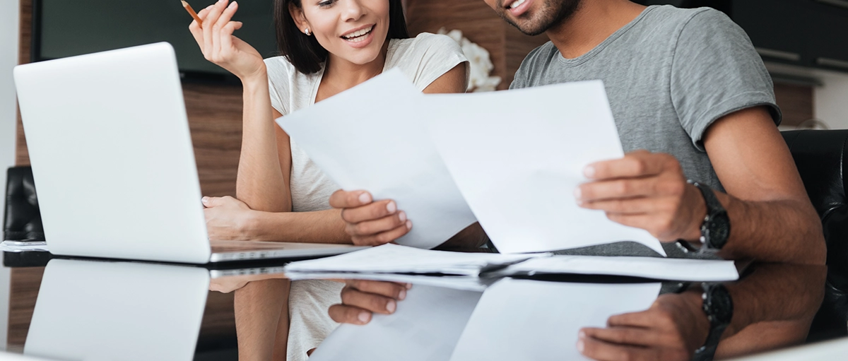 couple looking at finances with laptop in front of them