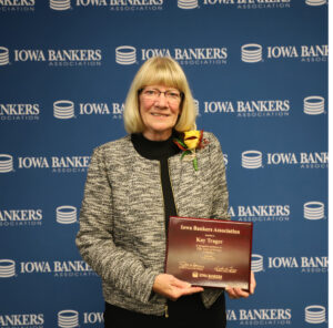 Kay Trager holding 50-year Banker Award plaque