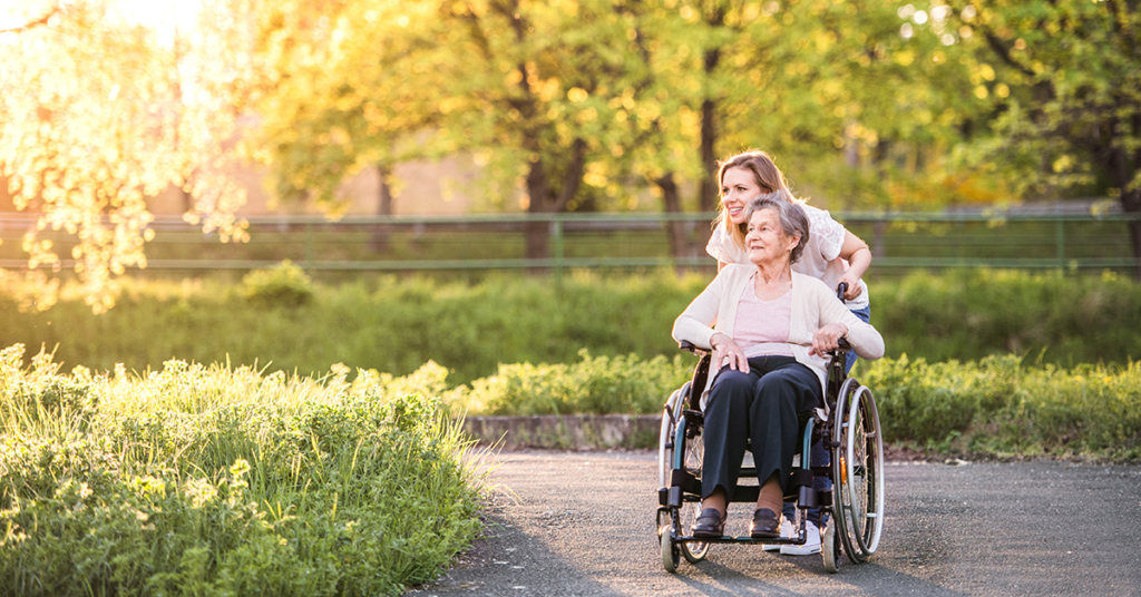 Granddaughter pushing grandmother in a wheelchair