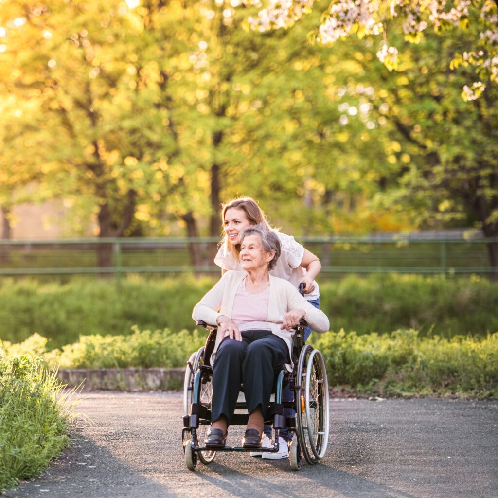 Granddaughter pushing grandmother in a wheelchair