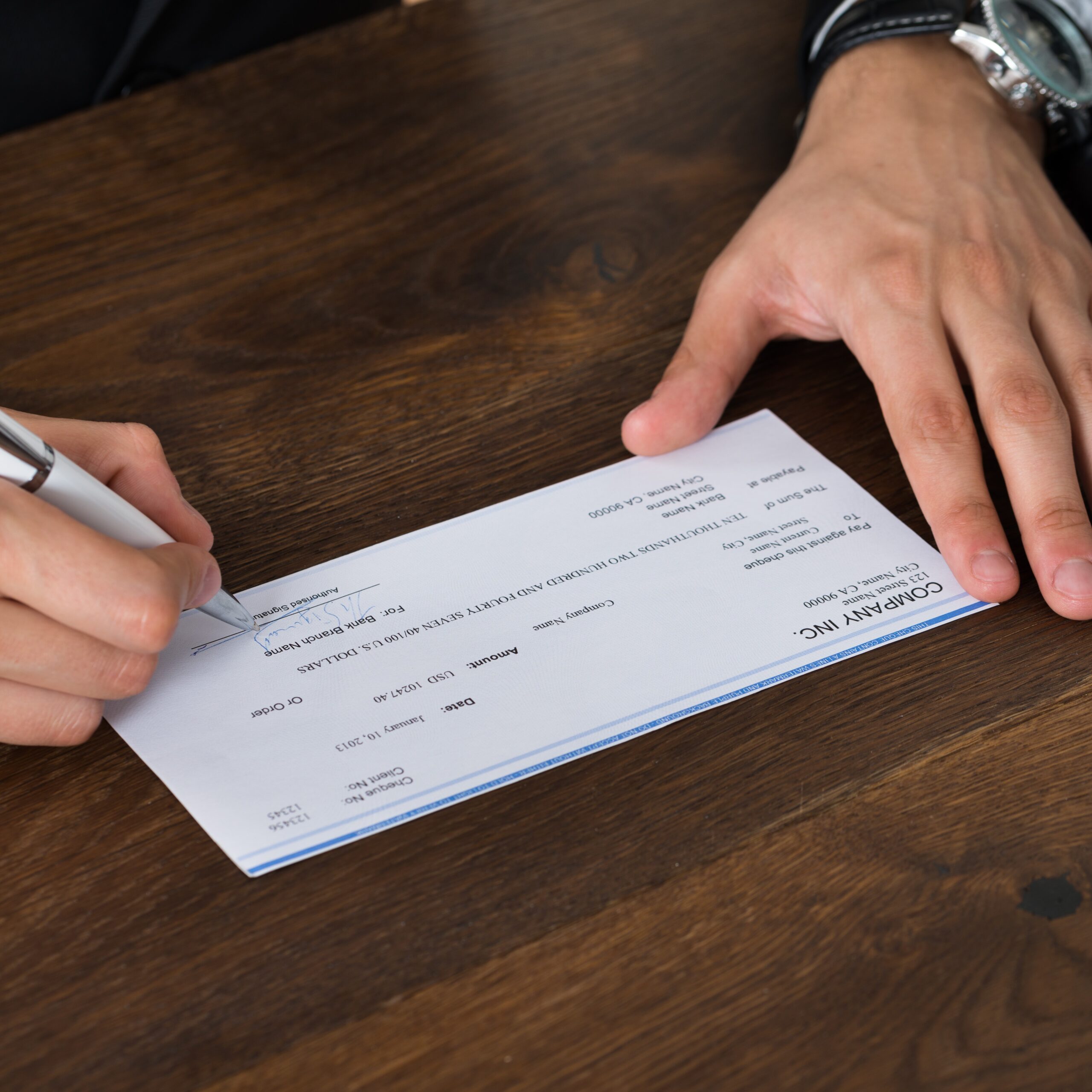 Business person signs a company check