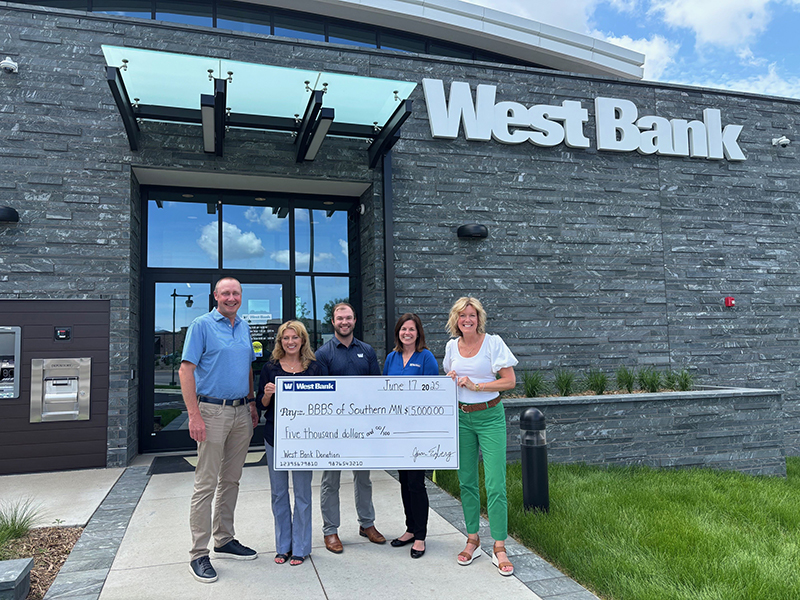 West Bankers presenting Michelle Redman from Big Brothers Big Sisters of Southern Minnesota with a giant West Bancorporation Foundation grant check.