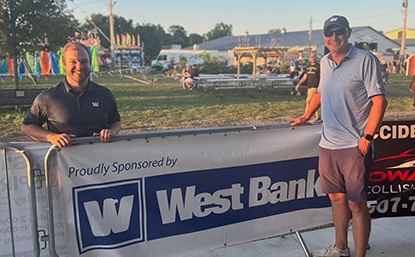 Rylee Muhr and Jason Eyberg with West Bank's sponsor banner at the Steele County Fair