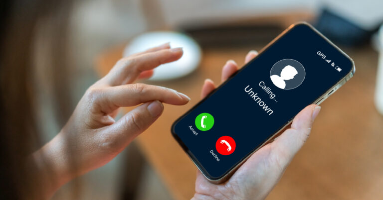 Woman considers whether to accept or decline a phone call from an unknown number