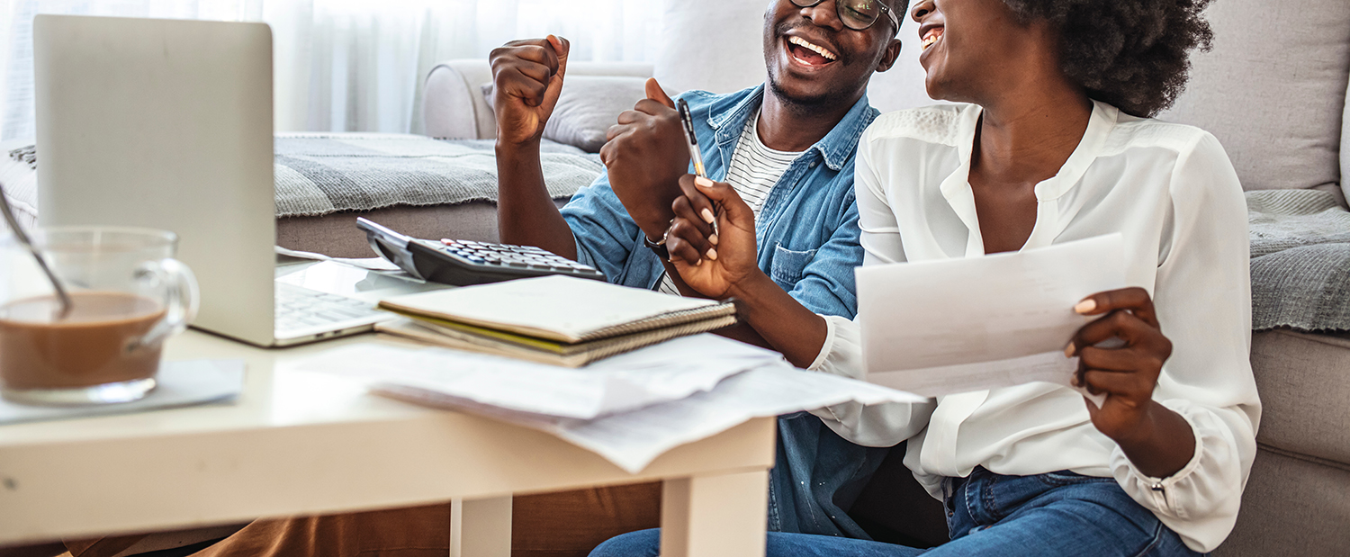 Positive couple reading documentation at home, checking agreement details together.