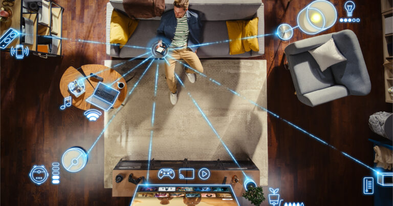 Man sitting on the couch on his smartphone with graphic lines connecting his phone to all of his devices connected to WiFi