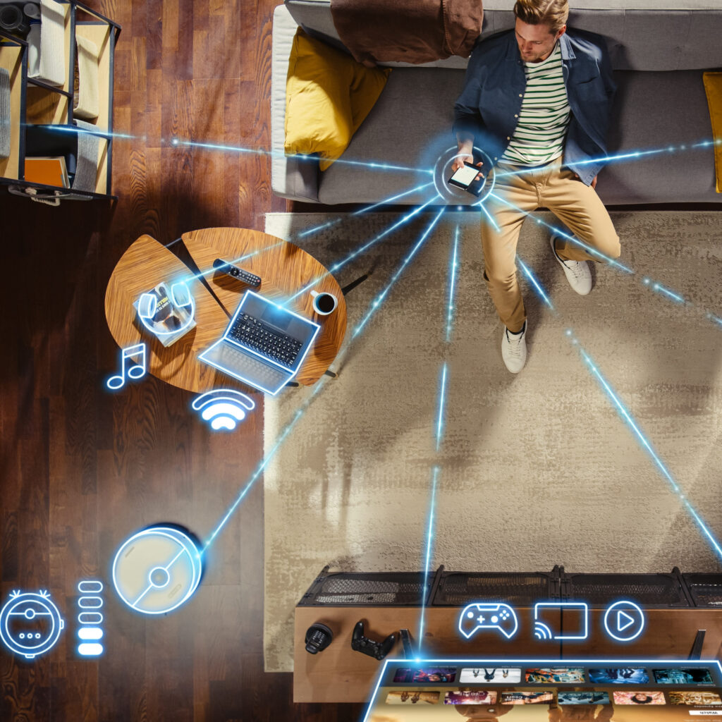 Man sitting on the couch on his smartphone with graphic lines connecting his phone to all of his devices connected to WiFi